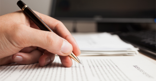 a hand holding a pen, ready to write.