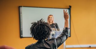 Woman raises her hand to suggest an idea