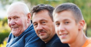 Grandfather, father and son pose for the camera