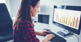 Woman looks at bar charts on her computer